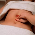 masseur giving woman stomach massage