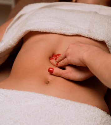masseur giving woman stomach massage