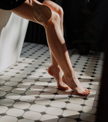 person in white pants standing on white and black floor tiles